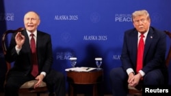 Володимир Путін (ліворуч) реагує на запитання про війну в Україні від іноземних журналістів під час церемонії фотографування з президентом США Дональдом Трампом в Анкориджі, штат Аляска, 15 серпня 2025 року