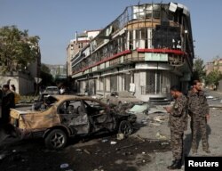 Members of Afghan security forces keep watch at the site of a nighttime car bomb blast in Kabul on August 4.