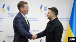 Президент Украины Владимир Зеленский пожимает руку президенту Raytheon Филу Джасперу перед их встречей в посольстве Украины в Вашингтоне, 17 октября 2025 года