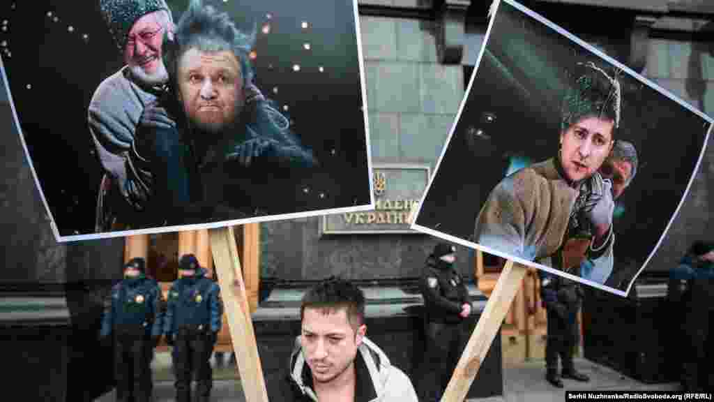 Активіст тримає плакати-колажі зроблені за мотивами кінообразів із фільму «Вечори на хуторі біля Диканьки»