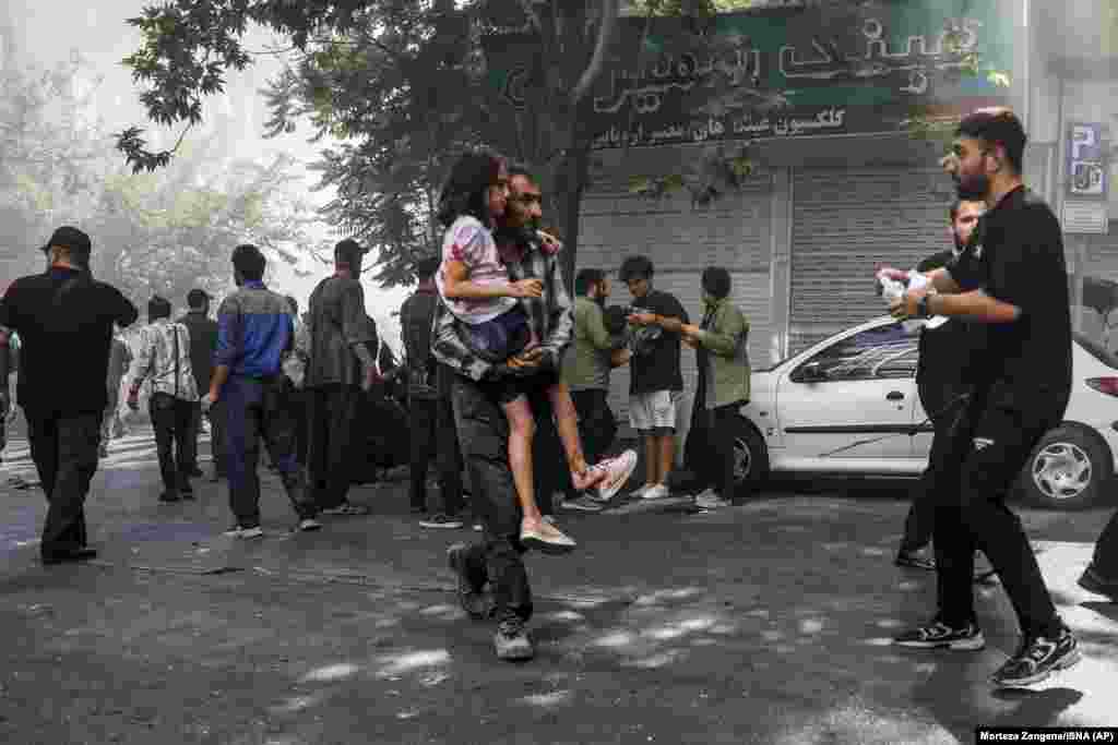 Чоловік несе поранену дівчинку після вибуху в центрі Тегерану 15 червня 2025 року на тлі ізраїльських ударів по цілях по всьому Ірану