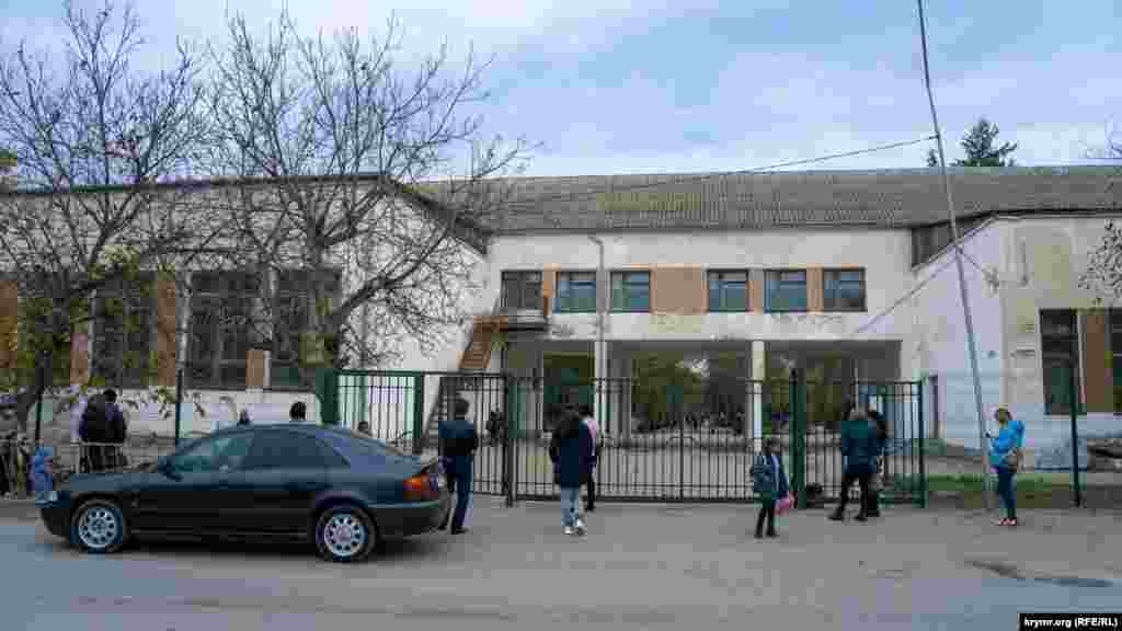 Родители встречают своих детей-школьников в «зоне безопасности» средней школы №1. На территорию учебного заведения им заходить запрещено