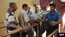 A security guard frisks visitors entering Baghdad's Imam Musa al-Kadhim shrine on July 27