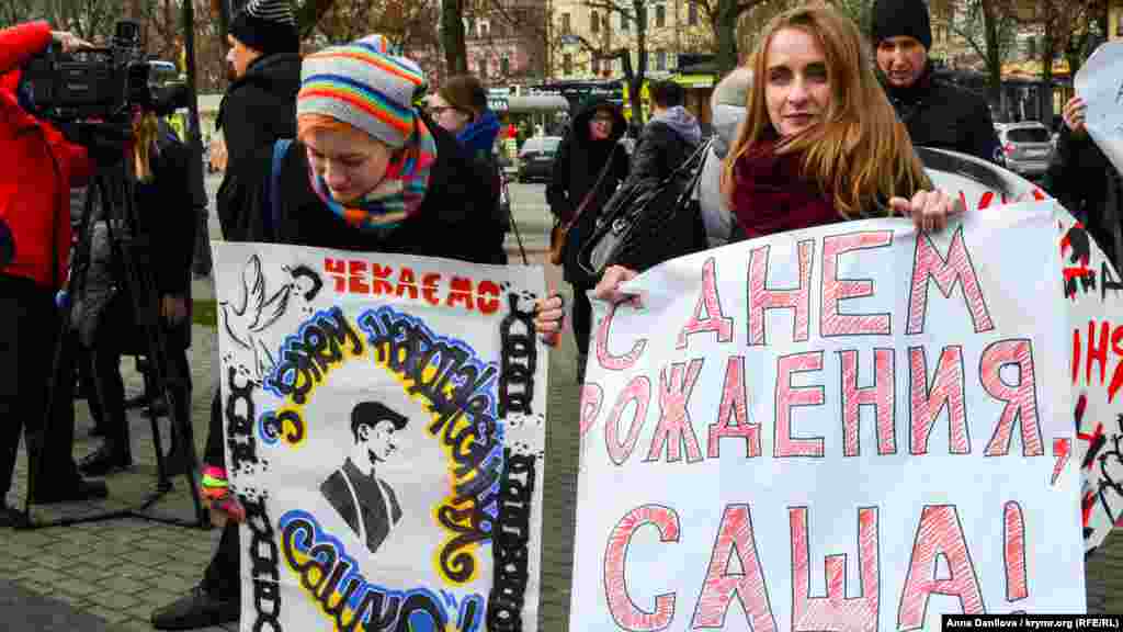 Во время акции активисты держали плакаты с надписями «Свободу крымским заложникам!», «С Днем рождения, Саша», «Ты еще на свободе? Помоги политзекам!» и другие.