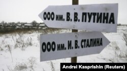 Росія. Вказівник в Алтайському краї в селі Горновка, який вказує, як дібратися до Товариства з обмеженою відповідальністю імені В.В. Путіна. А інший вказівник вказує напрямок до ТОВ імені Й.В. Сталіна. Село Горновка, 16 листопада 2007 року (архівне фото)