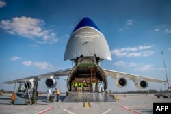 Працівники вивантажують коробки із захисним медичним обладнанням з українського вантажного літака Ан-124, що прибув з Китаю. Будапешт, 4 квітня 2020 року