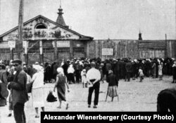 Черга за хлібом на харківському базарі у 1933 році. На фронтоні закритого магазину, як знущання, малюнок соковитих фруктів, які тут продавалися» (авторський підпис). Фото Александра Вінербергера