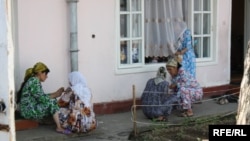 Женщины сидят у дома гадалки в ожидании своей очереди