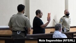 გიორგი რურუა მოსამართლეს უჩვენებს ვარდისფერ პარალონს.