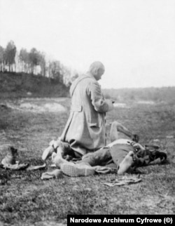 Священник поруч із польським солдатом, який помирає