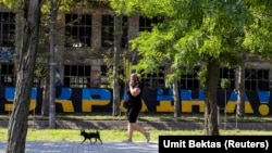 Женщина выгуливает свою собаку в городе Николаеве во время масштабного вторжения России в Украину. Николаев, 24 августа 2022 года