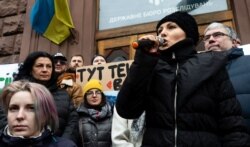 Народний депутат Софія Федина (з мікрофоном) біля будівлі ДБР, яку викликали для вручення письмового повідомлення про підозру у справі щодо погроз президенту України Володимиру Зеленському. Київ, 12 лютого 2020 року