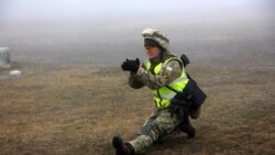 Артур Коротков наочно показує стойку для стрільби сидячи, шо мінімізує шанси бути ураженим ворогом