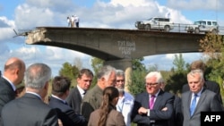 У правій частині фото керівники МЗС Німеччини і Франції – Франк-Вальтер Штайнмаєр та Жан-Марк Еро –неподалік Слов’янська біля моста, який був підірваний влітку 2014 року за наказом одного з ватажків угруповання «ДНР», російського полковника Ігоря Гіркіна. 15 вересня 2016 року