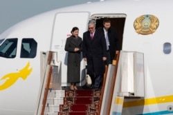 Токаєв спускається з літака, сходи якого вкриті традиційним килимом