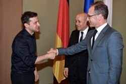 Президент України Володимир Зеленський (ліворуч) тисне руку німецькому міністру Гейко Маасу, в присутності шлави МЗС Франції Жан-Іва Ле Дріана. Київ, 30 травня 2019 року