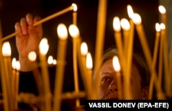 A woman lights a candle during the Christmas Mass at the St. Alexander Nevski Cathedral in Sofia.
