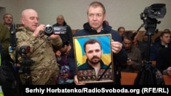 Портрет Артема Мірошниченка на засіданні суду в Бахмуті у справі про його вбивство, грудень 2019 рокуПід час засідання Донецького апеляційного суду в Бахмуті у справі вбивства громадського активіста Артема Мирошниченка, 11 грудня 2019 рок