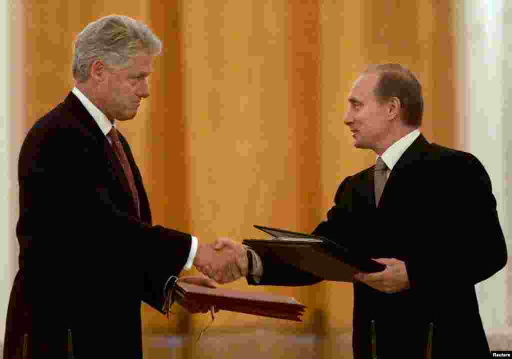 Președintele rus Vladimir Putin (dreapta) și președintele american Bill Clinton schimbă acorduri privind înființarea unui centru comun de avertizare pentru schimbul de informații privind lansările de rachete, la Moscova, pe 4 iunie 2000.