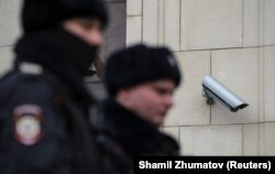 Российские полицейские проходят мимо уличной камеры в Москве, 2020 год