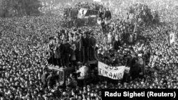 22 Decembrie 1989, Piața Palatului, în fața Comitetului Central al Partidului Comunist Român, astăzi sediul Ministerului de Interne, după fuga cu elicopterul a dictatorului Nicolae Ceaușescu, la orele 12:12-12:13. Un milion de oameni se aflau atunci pe străzile Bucureștiului.