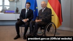 Wolfgang Schaeuble (desno), kao predsednik nemačkog Bundestaga, sedi u invalidskim kolicima pored predsednika Ukrajine Volodimira Zelenskog prilikom susreta u Berlinu, 18. juna 2019.