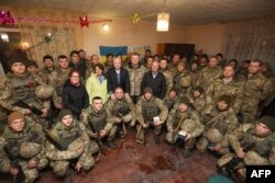 Президент Петро Порошенко і сенатори США Джон Маккейн, Ліндсі Ґрем та Еймі Клобучар разом із вояками України на командному пункті в районі населеного пункту Широкине під Маріуполем, 31 грудня 2016 року