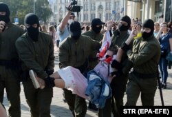 Омонівці несуть жінку до автозаку