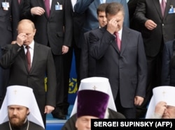 Президент России Владимир Путин (слева) и президент Украины Виктор Янукович (справа) крестятся во время богослужения, приуроченного к 1025-летию Крещения Украины-Руси. Киев, 27 июля 2013 года