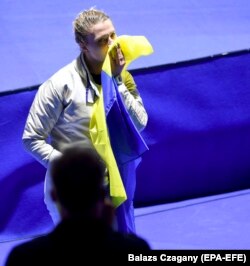 Українська шаблістка Ольга Харлан цілує український прапор після перемоги над росіянкою Софією Великої у фіналі індивідуальних змагань на шаблях на чемпіонаті світу з фехтування. Будапешт, 20 липня 2019 року