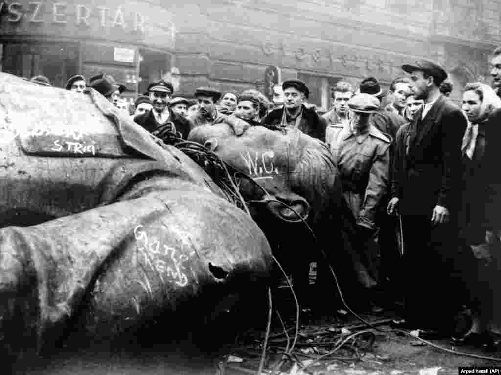 Унгарци соберени околу соборената статуа на Јосиф Сталин во средината на револуцијата во 1956 година.Во 1956 година, РСЕ беше критикувана за емитување на она што многумина го сметаа за поттикнување на антикомунистичко востание во Унгарија. Револуцијата беше задушена од советската армија, при што загинаа илјадници луѓе. Размислувајќи за емитувањата на РСЕ во Унгарија во 1956 година, кои вклучуваа некои технички совети за одржување на револуционерниот моментум, еден од поранешните директори на РСЕ заклучи дека „функцијата на [радиото] никогаш не била да им кажува на луѓето што да прават - особено во услови на насилни превирања“.