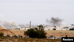 NTC fighters stand guard during heavy fighting as they push forward towards the center of Sirte on October 7.