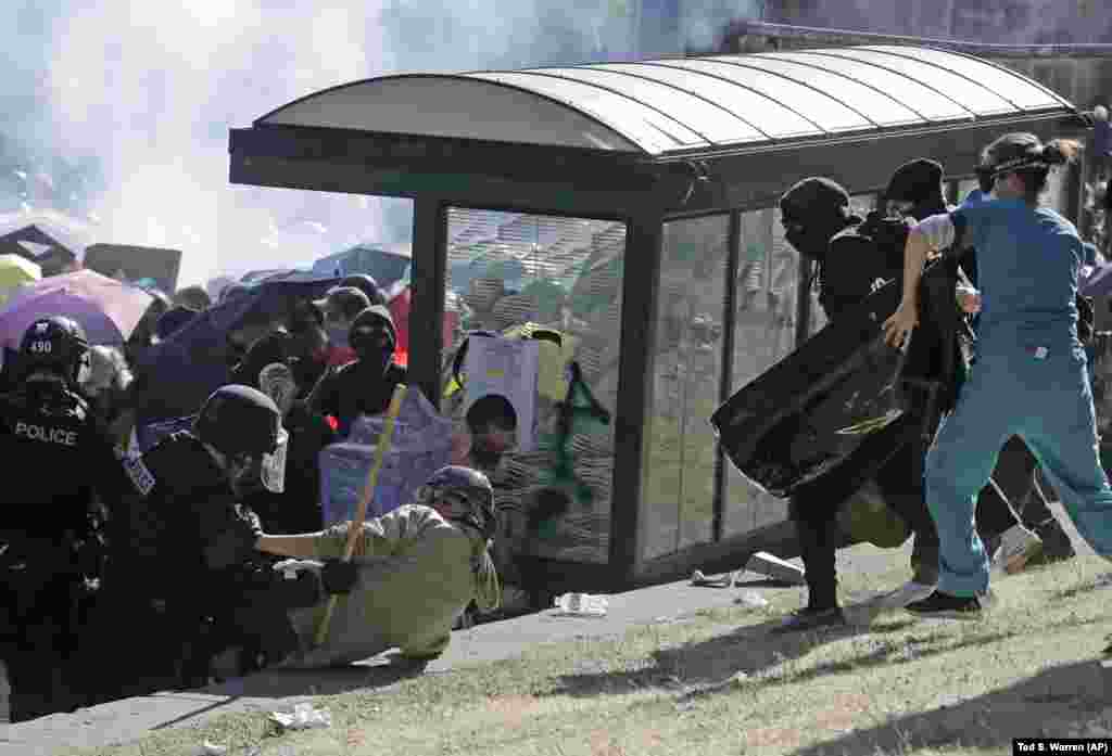 Медсестра (праворуч), яка надавала медичну допомогу протестувальникам, намагається дістатися до лівоцентриста, якого збила поліція під час зіткнення з активістами у Сіетлі (в районі Капітолійського пагорба), 25 липня 2020 року