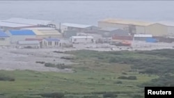 Мощная волна прокатилась мимо зданий, расположенных у берега, после сильного землетрясения, произошедшего у Камчатского полуострова, Сахалинская область, Россия, 30 июля 2025 года