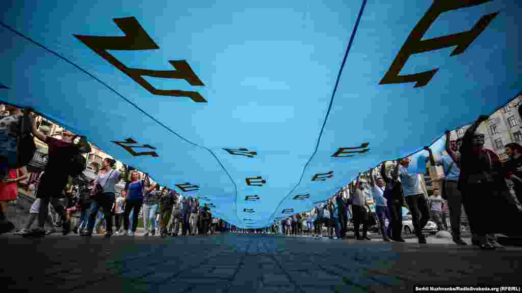 Мероприятие началось с шествия в центре Киева. Активисты развернули крымскотатарский флаг на пересечении улиц Крещатик и Богдана Хмельницкого, после чего прошли до Майдана Независимости