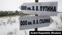 Росія. Вказівник в Алтайському краї в селі Горновка, який вказує, як дібратися до Товариства з обмеженою відповідальністю імені В.В. Путіна. А інший вказівник вказує напрямок до ТОВ імені Й.В. Сталіна. Село Горновка