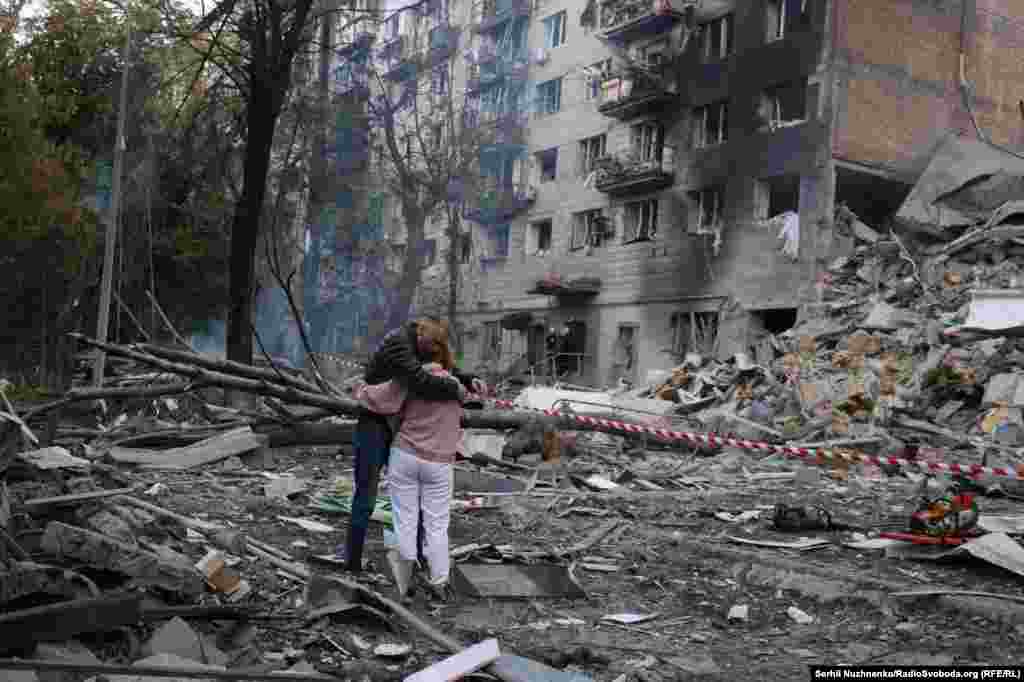 Супруги возле разрушенного дома в Киеве. Под завалами, вероятно, находится их сын