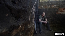 Український військовослужбовець 113-ї бригади територіальної оборони ЗСУ, сидить на ящику від боєприпасів у недобудованому бліндажі біля лінії фронту в Харківській області, Україна, 28 травня 2024 року