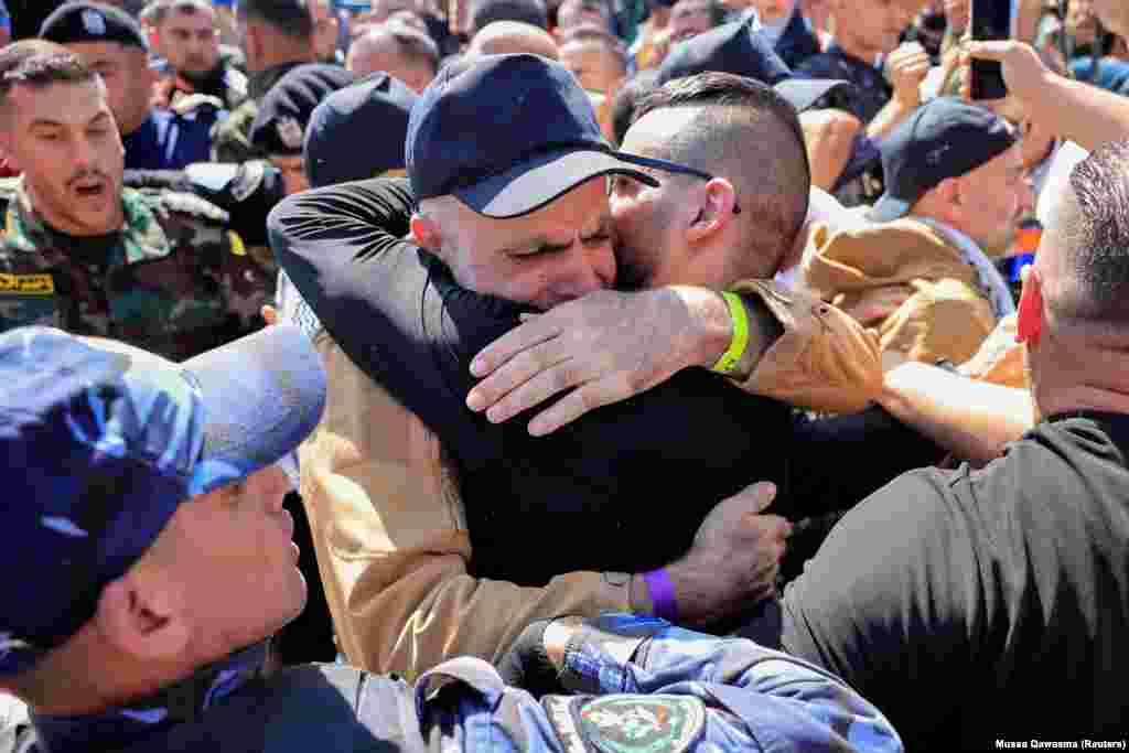 Освобожденный палестинский заключенный обнимает члена своей семьи после освобождения из израильской тюрьмы в рамках обмена заложниками и заключенными и соглашения о прекращении огня в секторе Газа между ХАМАС и Израилем, Рамалле, на оккупированном Израилем Западном берегу реки Иордан, 13 октября 2025 года. REUTERS/Mussa Qawasma