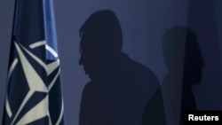 Александр Вучич (точнее, его силуэт) рядом с флагом НАТО