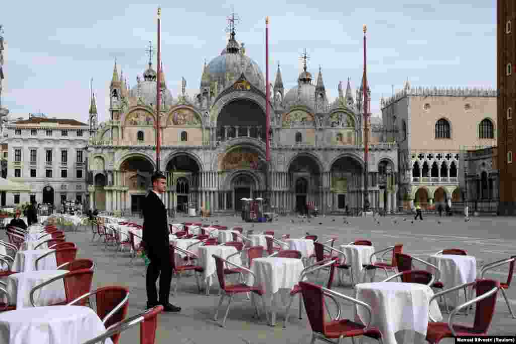 В Італії заборонені всі масові заходи, закриваються школи, університети, скасований  національний футбольний чемпіонат. Фото: офіціант ресторану стоїть на пустій центральній площі Сан-Марко у Венеції