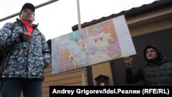 Ильхам Шагараев (слева) объясняет жителям поселка на сходе, чем грозят "дополнения" в Генплан.