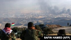 Ирак. Курдские бойцы наблюдают за операцией свои сил, поддержанных США, в городе Синджар 12 ноября 2015 года
