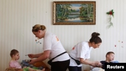 Няни ухаживают за детьми в приюте для инвалидов