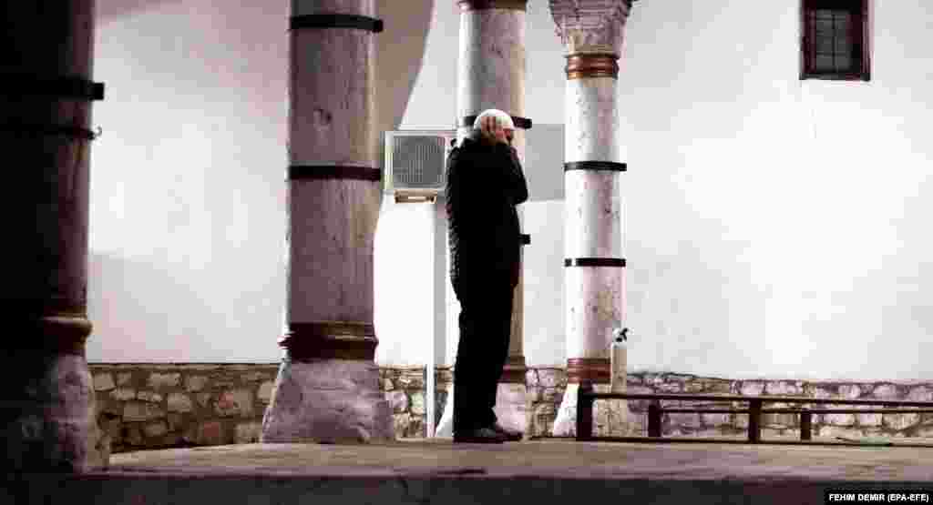 Сараево, Босния и Герцеговина. Верующий во время молитвы перед мечетью 