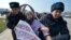 Kyrgyz police arrest a woman protesting against gender-based violence to mark International Women's Day in Bishkek in March 2020.