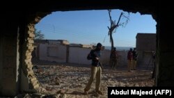 A Pakistani policeman stands guard at a badly damaged Hindu shrine after it was attacked by a mob in the Karak district, some 160 kilometers southeast of Peshawar.