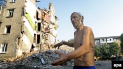 Мужчина возле разрушенного дома в Снежном. Июль 2014 года. Иллюстративное фото