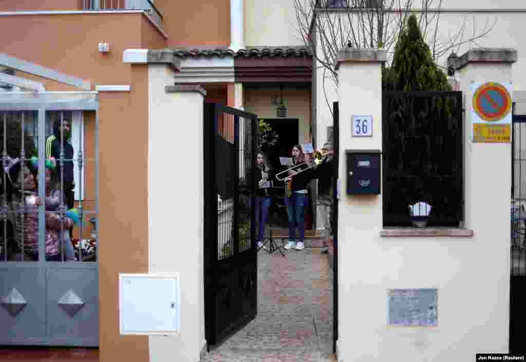 Оскільки всі офіційні заходи скасовані, люди грають пісень на балконах та подвір'ях. На фото сусіди слухають інструментальну гру Елеутеріо Мойя та його дочок, членів музичного колективу «Арунда» під час святкування Страсного тижня на карантині