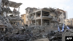 Пошкоджені будівлі та транспортні засоби видно в ізраїльському місті Рамат-Ган поблизу Тель-Авіва 14 червня 2025 року